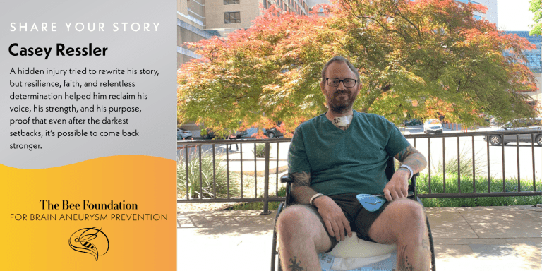 A man with glasses and facial hair sits in a wheelchair outdoors, with trees and buildings in the background. Text beside him shares his story of resilience after a brain aneurysm. Logo: The Bee Foundation for Brain Aneurysm Prevention.