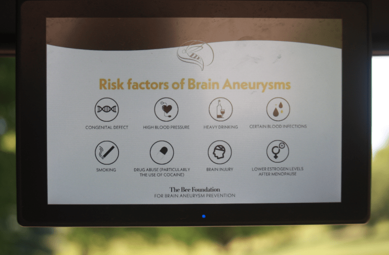 A screen displays Risk factors of Brain Aneurysms with icons and text for congenital defect, high blood pressure, heavy drinking, blood infections, smoking, drug abuse, brain injury, and low estrogen.