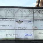 A large sign displays Event Sponsors and features multiple sponsor logos and names, including Chesco, Symetra, Hartford Funds, Fidelity Life, Cornerstone, Rainwalk, Manhattan Life, Toco, and others.