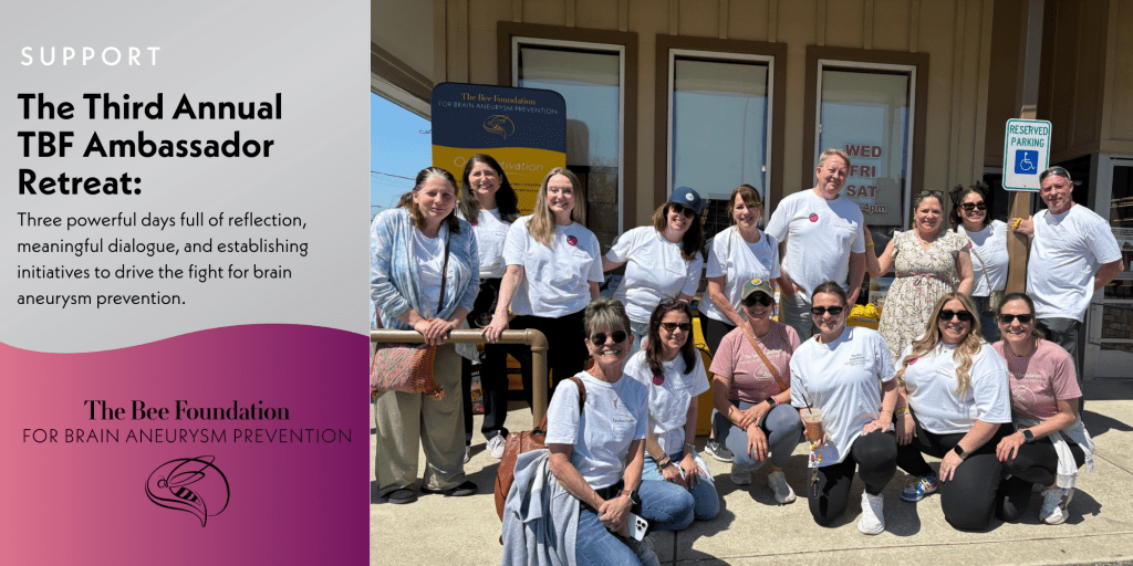 A group of smiling people wearing matching white shirts pose outside a building under a sign for The Bee Foundations Third Annual TBF Ambassador Retreat, supporting brain aneurysm prevention.